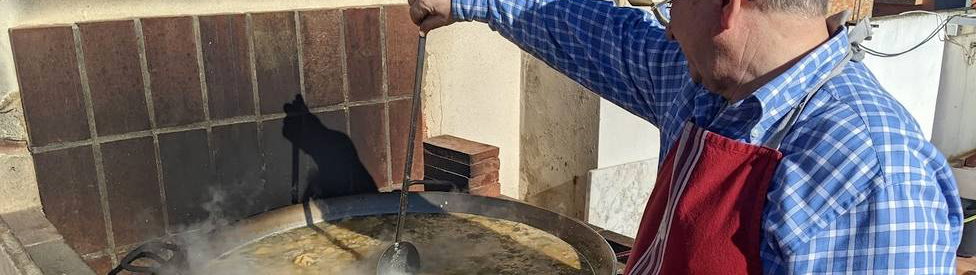 el hombre haciendo la paella de los domingos