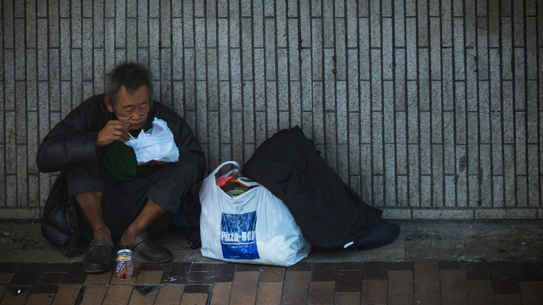 man sitting beside wall