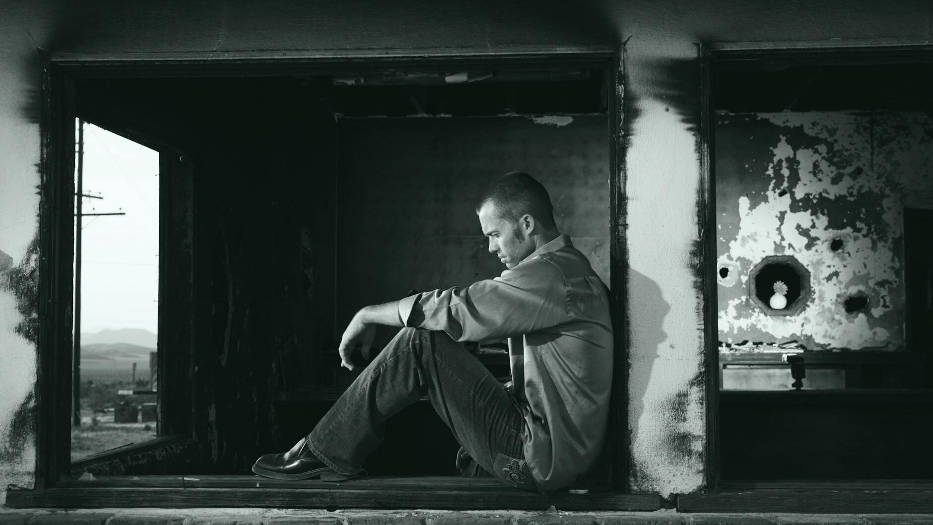 grayscale photo of man sitting